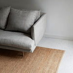 Nest Rug by Armadillo, handwoven from 100% natural jute with neatly finished ends, available in Natural and Charcoal tones, offering a minimalist design that adds warmth and texture to living spaces.