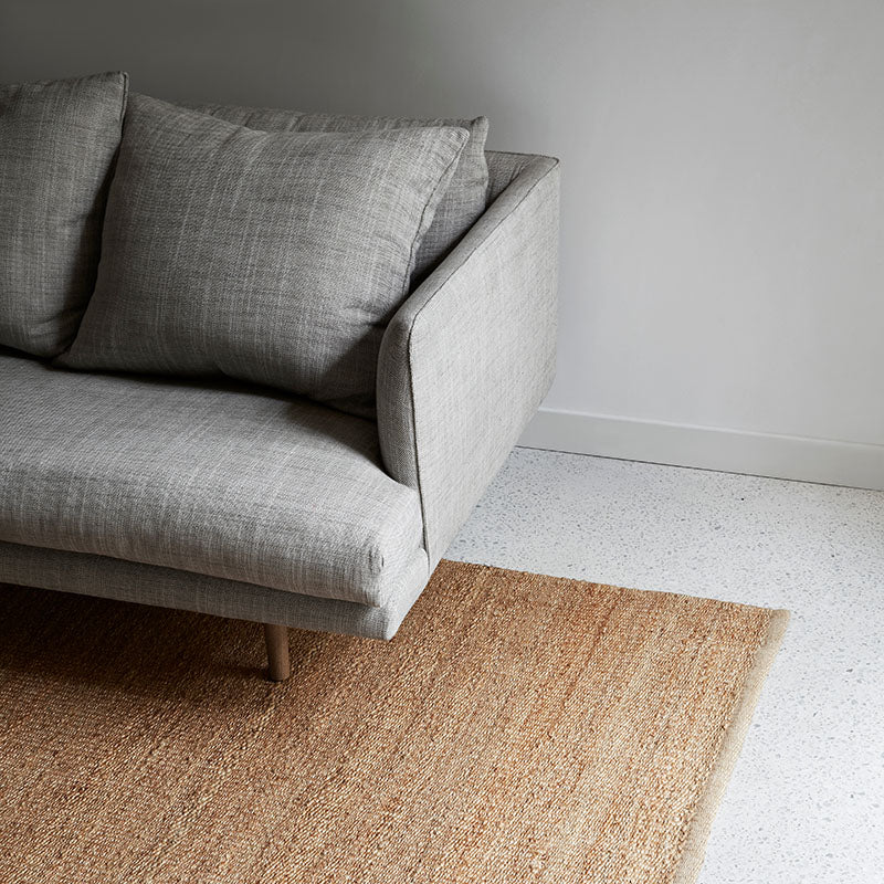 Nest Rug by Armadillo, handwoven from 100% natural jute with neatly finished ends, available in Natural and Charcoal tones, offering a minimalist design that adds warmth and texture to living spaces.