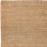 Nest vloerkleed van Armadillo, handgeweven van 100% natuurlijke jute met zorgvuldig afgewerkte uiteinden, verkrijgbaar in de kleuren Natural en Charcoal, biedt een minimalistisch ontwerp dat warmte en textuur toevoegt aan woonruimtes.