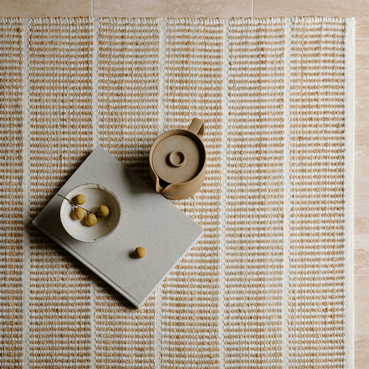 Trellis Rug by Armadillo, handwoven from a blend of wool and jute, featuring uniform stripes in color combinations such as Natural & White, Natural & Bison, and Natural & Sandstone, offering a contemporary take on traditional Moroccan Tuareg designs.