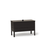 A Line Storage Bench by Form & Refine, crafted from solid European oak with a minimalist design, featuring a leather handle and two spacious compartments for organized storage, available in oak, white oak, and black finishes.