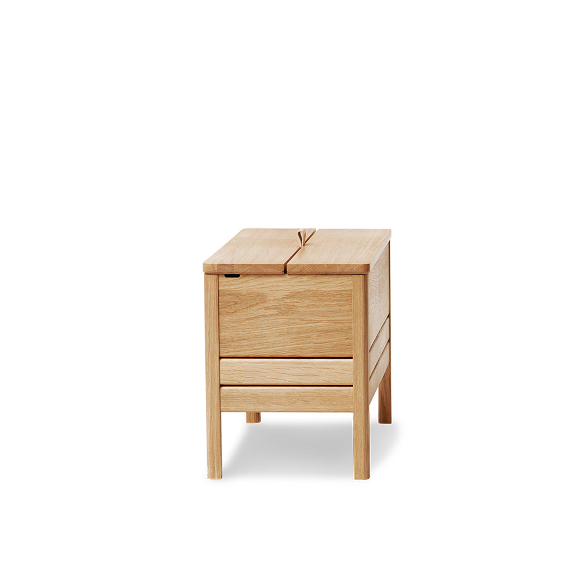 A Line opbergbank van Form & Refine, vervaardigd uit massief Europees eikenhout met een minimalistisch ontwerp, voorzien van een leren handvat en twee ruime compartimenten voor georganiseerde opbergruimte, verkrijgbaar in eiken, wit eiken en zwart eiken afwerkingen.