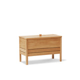 A Line Storage Bench by Form & Refine, crafted from solid European oak with a minimalist design, featuring a leather handle and two spacious compartments for organized storage, available in oak, white oak, and black finishes.