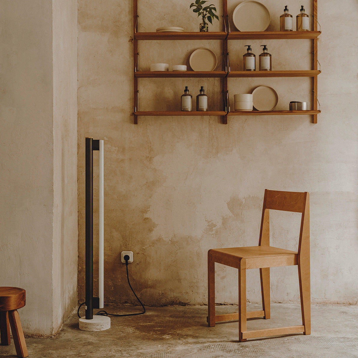 Eiffel Floor Lamp by Frama featuring a minimalist design with a stainless steel frame, opal glass LED tube, and a natural stone base, offering dimmable ambient lighting suitable for various interior settings.