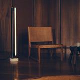 Eiffel Vloerlamp van Frama met een minimalistisch ontwerp, roestvrijstalen frame, opaalglazen LED-buis en een natuurstenen voet, biedt dimbaar sfeerverlichting geschikt voor diverse interieurinstellingen.