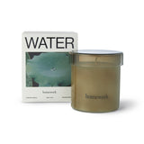 Homework Water Scented Candle – 180g – A 100% natural candle handcrafted in the UK, featuring a silky blend of rapeseed and coconut wax. Fragranced with responsibly-sourced essential oils, this candle offers a scent profile of citrus, water, wood, and spice. Housed in a warm-toned lidded glass jar that can be reused after the candle has burned down. Palm-free and vegan. Burn time: 35–40 hours.