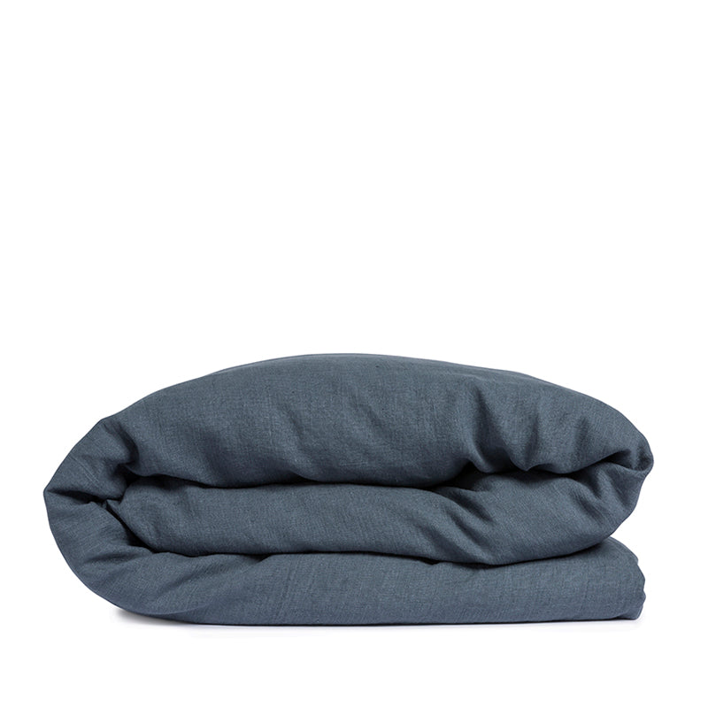 By Mölle's Faded Blue linen duvet cover, crafted from 100% pre-washed European flax linen. This soft blue shade complements various interior styles, offering a serene and natural ambiance. The duvet cover features a choice of wooden buttons or a full-width tuck-in flap closure, combining functionality with timeless design.