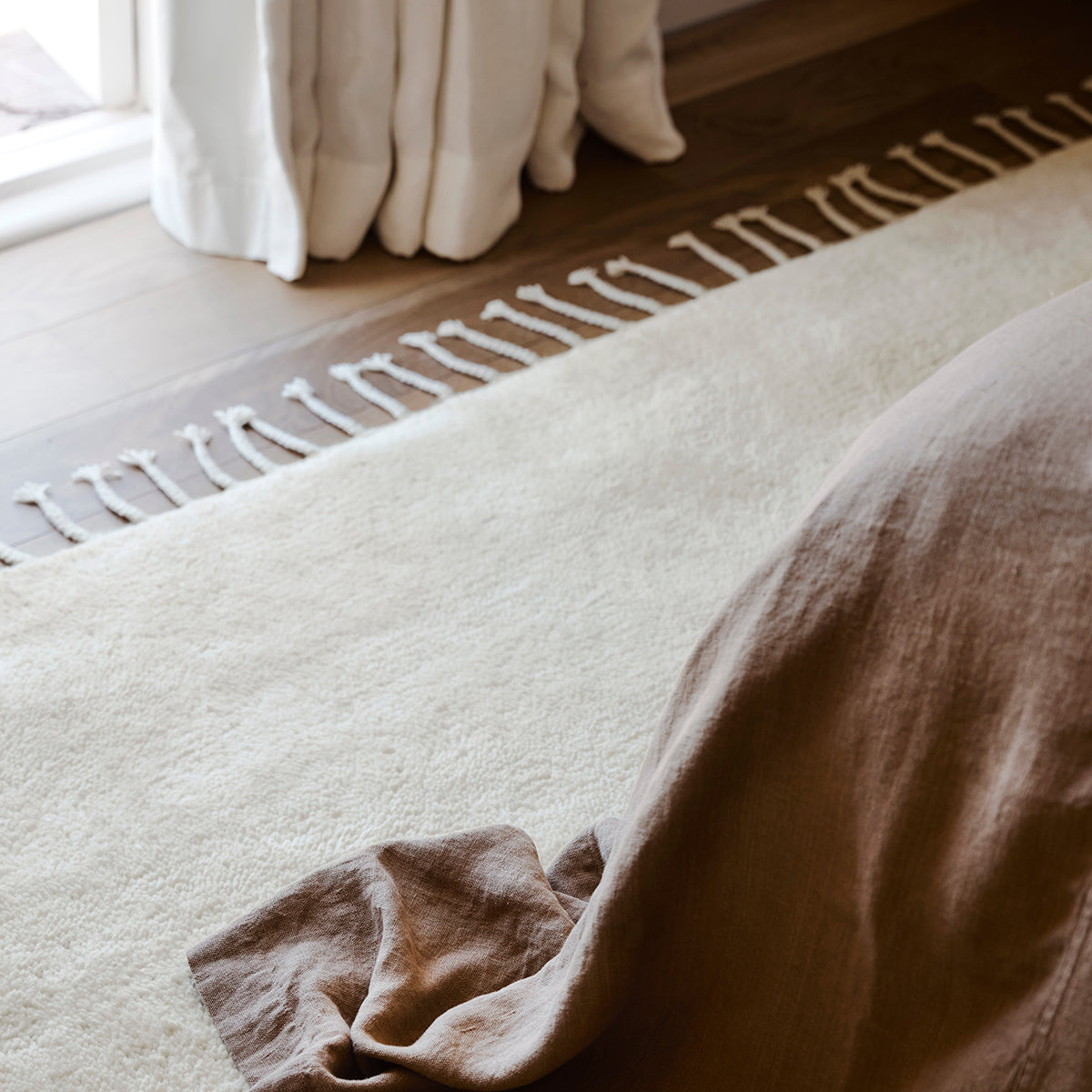 Petra vloerkleed van Armadillo, met de hand geknoopt van pure wol, verkrijgbaar in diverse neutrale tinten, met een subtiele textuur en minimalistisch ontwerp dat warmte en elegantie toevoegt aan elk interieur.