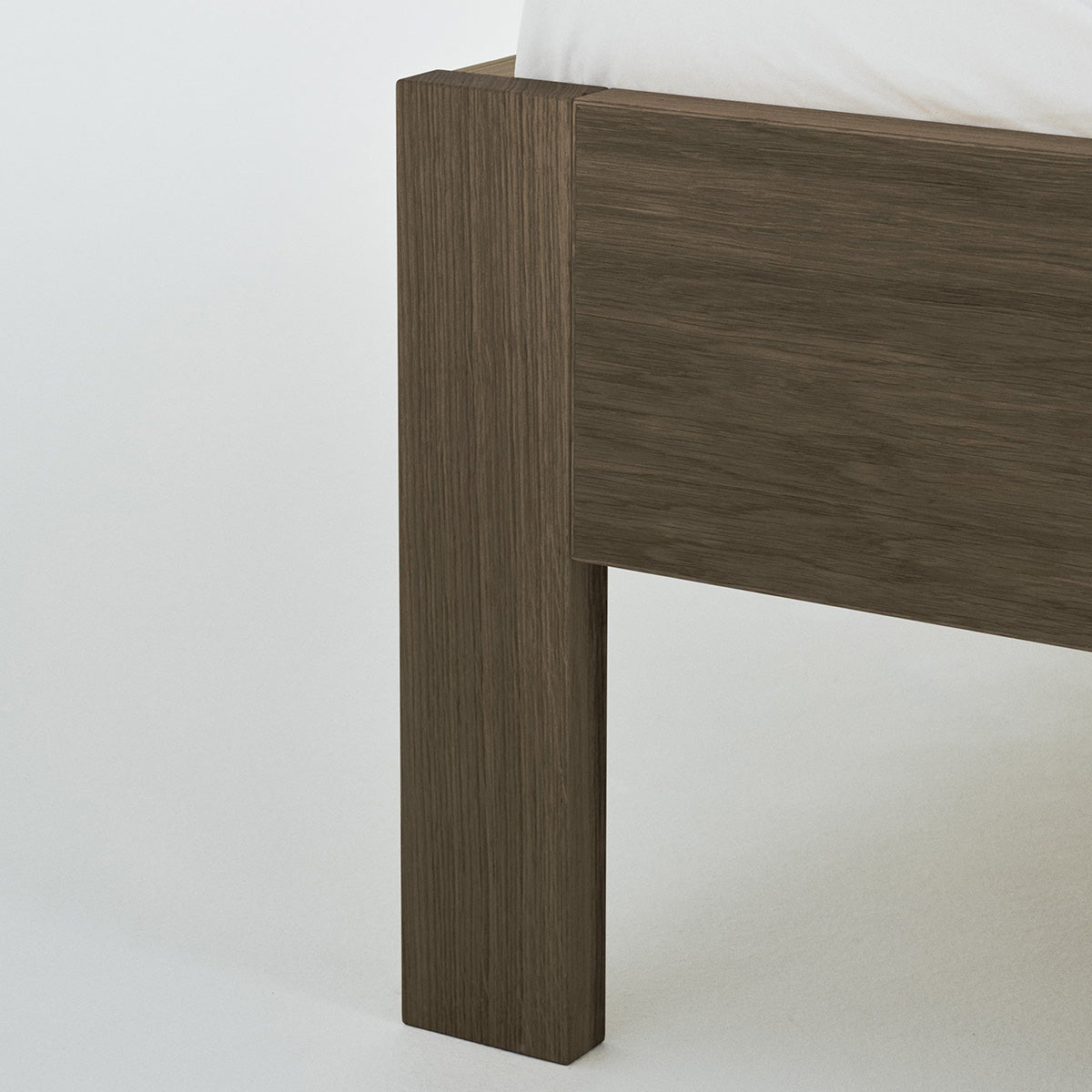 Ejer Bed Frame by RYE available in oiled oak, black stained oak, or smoked oak finishes, featuring a minimalist design with clean lines and a slightly inclined headboard, crafted for a tranquil and restful sleep environment