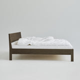 Ejer Bed Frame van RYE beschikbaar in geolied eiken, zwart gebeitst eiken of gerookt eiken, met een minimalistisch ontwerp, strakke lijnen en een licht hellend hoofdeinde, ontworpen voor een rustige en rustgevende slaapomgeving.