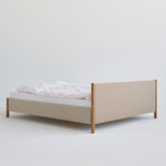 Veng Bed Frame van RYE met een minimalistisch ontwerp, voorzien van een met linnen beklede frame en massief eikenhouten poten, die Scandinavisch vakmanschap en tijdloze elegantie belichamen.