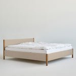 Veng Bed Frame by RYE featuring a minimalist design with a linen-upholstered frame and solid oak wood posts, embodying Scandinavian craftsmanship and timeless elegance.