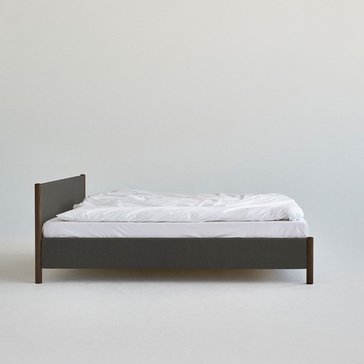 Veng Bed Frame van RYE met een minimalistisch ontwerp, voorzien van een met linnen beklede frame en massief eikenhouten poten, die Scandinavisch vakmanschap en tijdloze elegantie belichamen.