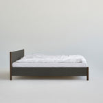 Veng Bed Frame van RYE met een minimalistisch ontwerp, voorzien van een met linnen beklede frame en massief eikenhouten poten, die Scandinavisch vakmanschap en tijdloze elegantie belichamen.