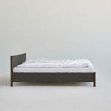Veng Bed Frame van RYE met een minimalistisch ontwerp, voorzien van een met linnen beklede frame en massief eikenhouten poten, die Scandinavisch vakmanschap en tijdloze elegantie belichamen.