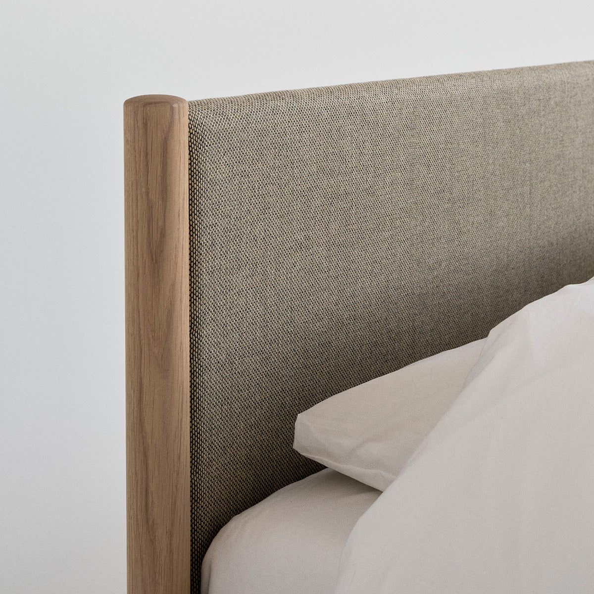 Minimalist wooden bed frame designed by Rye Sleep and available at By Mölle. Featuring clean Scandinavian lines, a low-profile form, and a softly upholstered headboard, this bed blends timeless design with natural materials for a calm, modern bedroom atmosphere