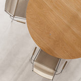 Mio Dining Table by Thorup Copenhagen featuring a minimalist round design crafted from FSC-certified solid oak, available in oiled or stained finishes, with distinctive steel fasteners and an organic silhouette