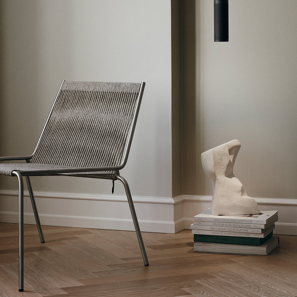 Noel Lounge Chair by Thorup Copenhagen with a raw steel frame and soft wool upholstery, showcasing a minimalist design with natural, tactile materials.