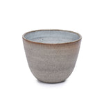 Hand-thrown ceramic cup in soft grey tones with a matte interior and minimal rounded shape