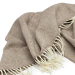 Lambswool Throw in Cocoa by By Mölle – 100% Merino lambswool woven in a classic herringbone pattern, combining natural cream and warm brown shades. Measuring 140 x 200 cm, this lightweight yet warm throw is crafted in Europe and machine washable on a wool program. Ideal for adding a cozy touch to your living space.