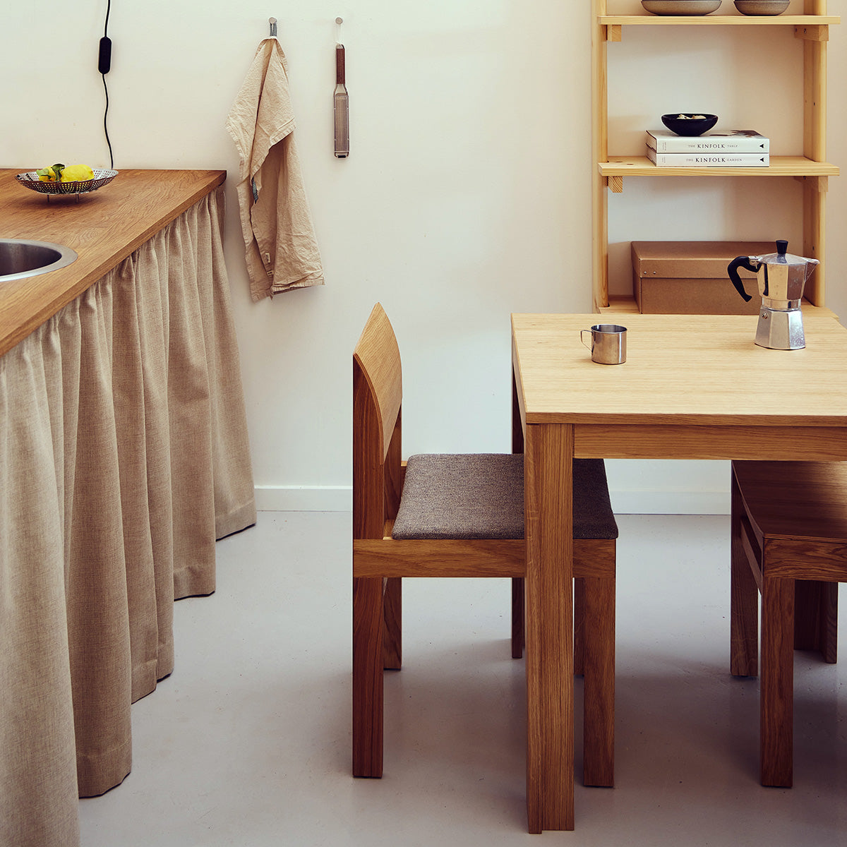 Square table with ultra-slim tabletop and recessed legs made of solid oak. A subtle shadow line between the top and frame creates a light floating effect. Modular design allows multiple tables to connect seamlessly in a row. Durable and elegant, ideal for everyday use in contemporary interiors.