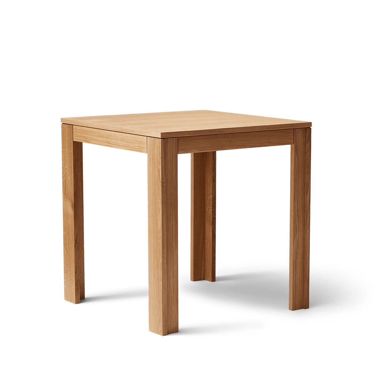 Vierkante tafel met ultra-dun tafelblad en verzonken poten van massief eikenhout. Subtiele schaduwlijn tussen blad en frame zorgt voor een licht zwevend effect. Modulair ontwerp dat meerdere tafels naadloos in een rij verbindt. Robuust en elegant, perfect voor dagelijks gebruik in moderne interieurs.