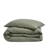 By Mölle's olive linen duvet cover, crafted from 100% pre-washed European flax linen, features a soft green hue inspired by olive tree leaves. This breathable and hypoallergenic fabric offers comfort year-round and is available with either wooden buttons or a tuck-in flap closure.