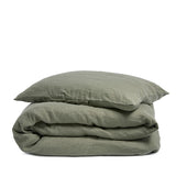 By Mölle's olive linen duvet cover, crafted from 100% pre-washed European flax linen, features a soft green hue inspired by olive tree leaves. This breathable and hypoallergenic fabric offers comfort year-round and is available with either wooden buttons or a tuck-in flap closure.