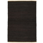 Nest Rug by Armadillo, handwoven from 100% natural jute with neatly finished ends, available in Natural and Charcoal tones, offering a minimalist design that adds warmth and texture to living spaces.