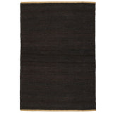 Nest Rug by Armadillo, handwoven from 100% natural jute with neatly finished ends, available in Natural and Charcoal tones, offering a minimalist design that adds warmth and texture to living spaces.