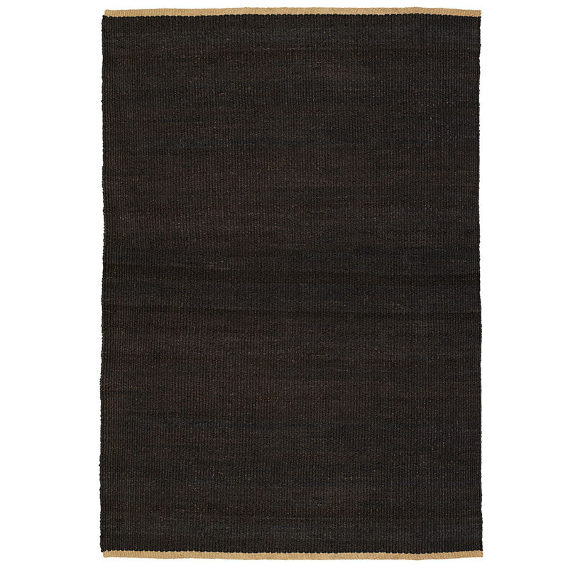 Nest Rug by Armadillo, handwoven from 100% natural jute with neatly finished ends, available in Natural and Charcoal tones, offering a minimalist design that adds warmth and texture to living spaces.