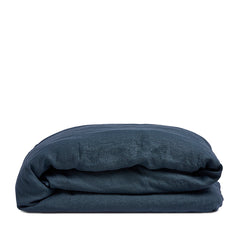 By Mölle's indigo linen duvet cover, crafted from 100% pre-washed European flax linen, features a deep indigo blue hue. The breathable and hypoallergenic fabric provides comfort year-round and is available with either wooden buttons or a tuck-in flap closure.
