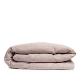 By Mölle's Pink Salt linen duvet cover, crafted from 100% pre-washed European flax linen, features a chambray weave combining pink and off-white threads. This warm pink hue adds a soft touch to any bedroom. The duvet cover is available with either wooden buttons or a tuck-in flap closure.