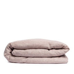 By Mölle's Pink Salt linen duvet cover, crafted from 100% pre-washed European flax linen, features a chambray weave combining pink and off-white threads. This warm pink hue adds a soft touch to any bedroom. The duvet cover is available with either wooden buttons or a tuck-in flap closure.