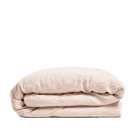 By Mölle's blush linen duvet cover, crafted from 100% pre-washed European flax linen, features a soft, powdery pink hue achieved through chambray weaving. This breathable and hypoallergenic fabric offers comfort year-round and is available with either wooden buttons or a full-width tuck-in flap closure.