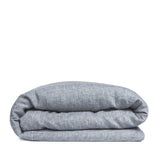 By Mölle's Cloudy Blue linen duvet cover, crafted from 100% pre-washed European flax linen, features a chambray weave combining faded blue and off-white yarns. This breathable and hypoallergenic fabric offers comfort year-round and is available with either wooden buttons or a tuck-in flap closure. Handmade in the Netherlands with respect for the earth.