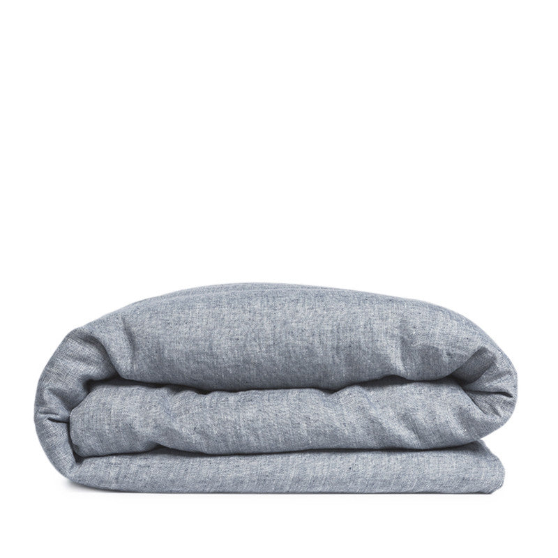 By Mölle's Cloudy Blue linen duvet cover, crafted from 100% pre-washed European flax linen, features a chambray weave combining faded blue and off-white yarns. This breathable and hypoallergenic fabric offers comfort year-round and is available with either wooden buttons or a tuck-in flap closure. Handmade in the Netherlands with respect for the earth.