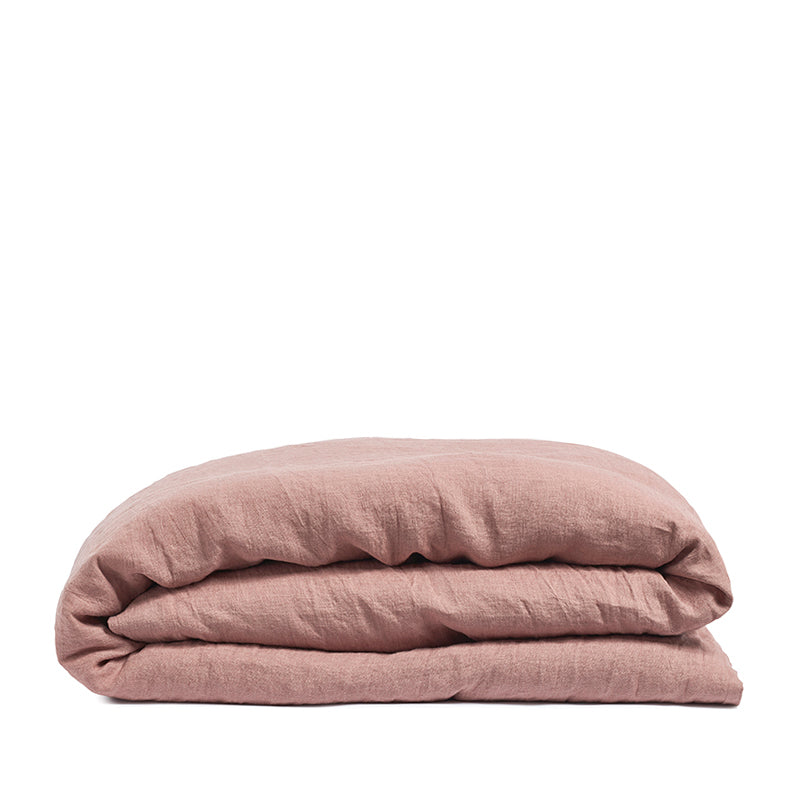 By Mölle's coral linen duvet cover made from 100% pre-washed European flax linen, featuring a soft, breathable fabric with a natural texture and a choice of wooden buttons or tuck-in flap closure