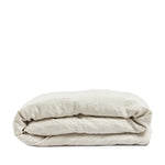 By Mölle's Sea Shell linen duvet cover, crafted from 100% pre-washed European flax linen, features a soft beige and off-white chambray weave. This breathable and hypoallergenic fabric offers comfort year-round and is available with either wooden buttons or a tuck-in flap closure. Handmade in the Netherlands with respect for the earth.