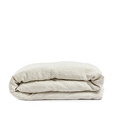 By Mölle's Sea Shell linen duvet cover, crafted from 100% pre-washed European flax linen, features a soft beige and off-white chambray weave. This breathable and hypoallergenic fabric offers comfort year-round and is available with either wooden buttons or a tuck-in flap closure. Handmade in the Netherlands with respect for the earth.
