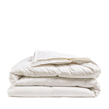 By Mölle's Recycled Down All Seasons Duvet Insert, crafted from 100% GOTS certified organic cotton and filled with 70% Dutch recycled down and 30% recycled feathers. This eco-friendly duvet features box stitching to ensure even distribution of the fill, providing consistent warmth throughout the night. The duvet is suitable for allergy sufferers, certified with the Nomite® label.