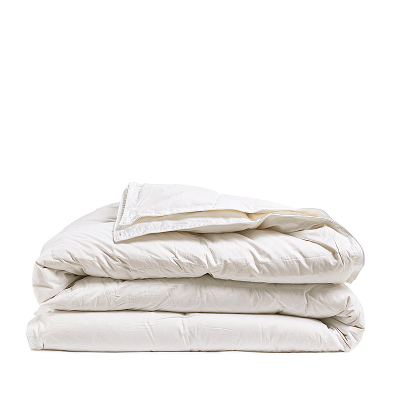 By Mölle's Recycled Down All Seasons Duvet Insert, crafted from 100% GOTS certified organic cotton and filled with 70% Dutch recycled down and 30% recycled feathers. This eco-friendly duvet features box stitching to ensure even distribution of the fill, providing consistent warmth throughout the night. The duvet is suitable for allergy sufferers, certified with the Nomite® label.