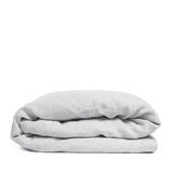 By Mölle's Misty Grey linen duvet cover, crafted from 100% pre-washed European flax linen, features a versatile light grey shade with a subtle blue undertone. The chambray weave combines light grey and off-white yarns, adding depth and character to the fabric. This breathable and hypoallergenic linen offers comfort year-round and is available with either wooden buttons or a full-width tuck-in flap closure. Handmade in the Netherlands with respect for the earth.