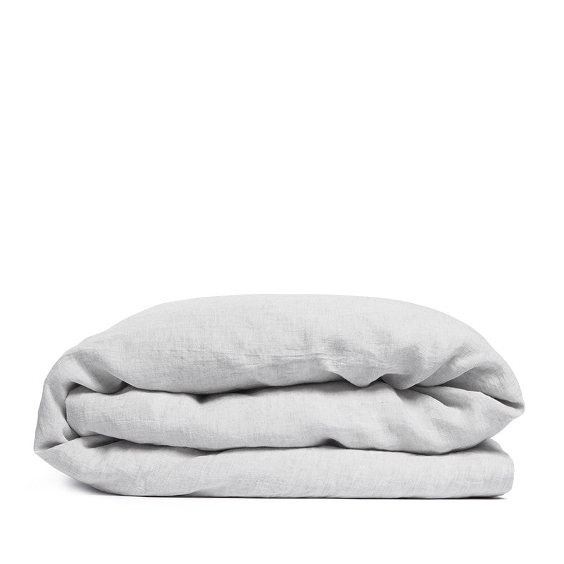 By Mölle's Misty Grey linen duvet cover, crafted from 100% pre-washed European flax linen, features a versatile light grey shade with a subtle blue undertone. The chambray weave combines light grey and off-white yarns, adding depth and character to the fabric. This breathable and hypoallergenic linen offers comfort year-round and is available with either wooden buttons or a full-width tuck-in flap closure. Handmade in the Netherlands with respect for the earth.