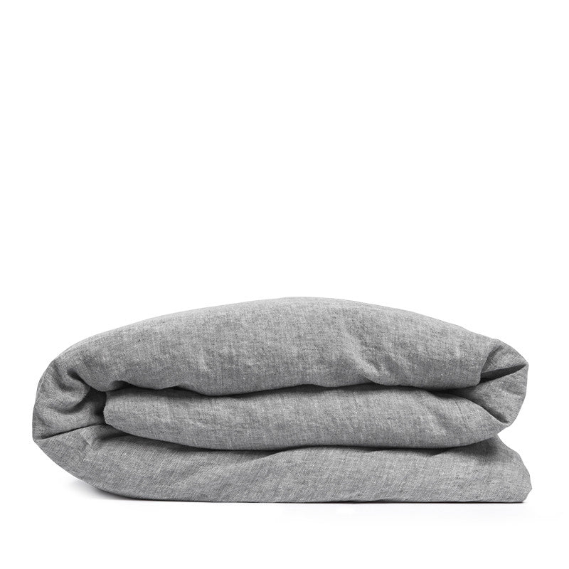 By Mölle's Pebble linen duvet cover, crafted from 100% pre-washed European flax linen, features a soft, contemporary grey shade achieved through chambray weaving with grey and off-white yarns. This breathable and hypoallergenic fabric offers comfort year-round and is available with either wooden buttons or a full-width tuck-in flap closure. Handmade in the Netherlands with respect for the earth.