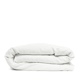 By Mölle's Pure White linen duvet cover, crafted from 100% pre-washed European flax linen, offers a crisp and fresh aesthetic. This breathable and hypoallergenic fabric provides comfort year-round and is available with either wooden buttons or a full-width tuck-in flap closure. Handmade in the Netherlands with respect for the earth.