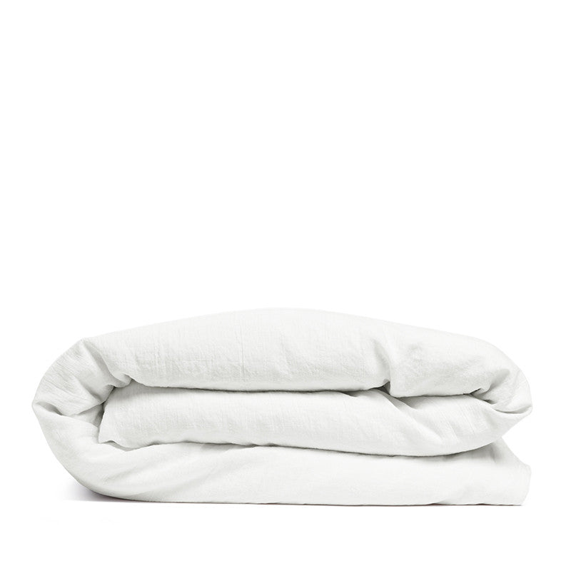 By Mölle's Pure White linen duvet cover, crafted from 100% pre-washed European flax linen, offers a crisp and fresh aesthetic. This breathable and hypoallergenic fabric provides comfort year-round and is available with either wooden buttons or a full-width tuck-in flap closure. Handmade in the Netherlands with respect for the earth.