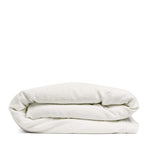 By Mölle's Warm White linen duvet cover, crafted from 100% pre-washed European flax linen, features a pure tone with a touch of cream. The high-quality chambray weave adds depth and character. Available with wooden buttons or a full-width tuck-in flap closure, this breathable and hypoallergenic fabric offers year-round comfort.