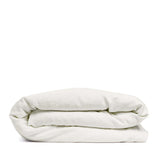 By Mölle's Warm White linen duvet cover, crafted from 100% pre-washed European flax linen, features a pure tone with a touch of cream. The high-quality chambray weave adds depth and character. Available with wooden buttons or a full-width tuck-in flap closure, this breathable and hypoallergenic fabric offers year-round comfort.
