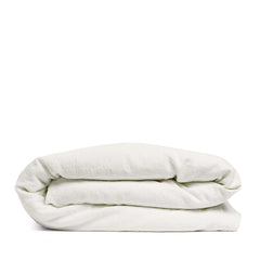 By Mölle's Warm White linen duvet cover, crafted from 100% pre-washed European flax linen, features a pure tone with a touch of cream. The high-quality chambray weave adds depth and character. Available with wooden buttons or a full-width tuck-in flap closure, this breathable and hypoallergenic fabric offers year-round comfort.